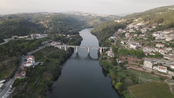 Aerial descending approach of Ponte De Pedra old historic bridge at Entre-Os-Rios in Portugal