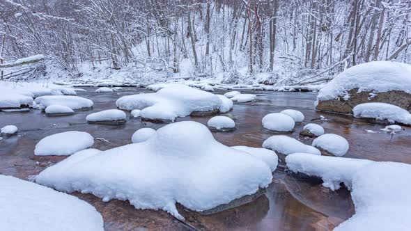 The wild frozen river in the winter wood after snow storm, 4k dolly timelapse video