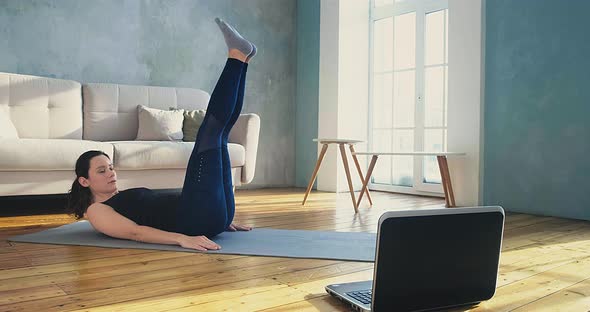 Woman in Skinny Tracksuit Does Crunches and Leg Lifts alt