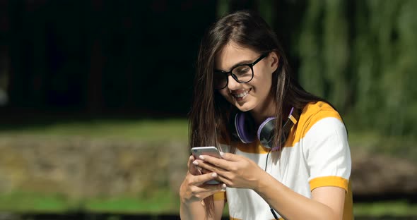 Woman Browsing Smartphone in Park