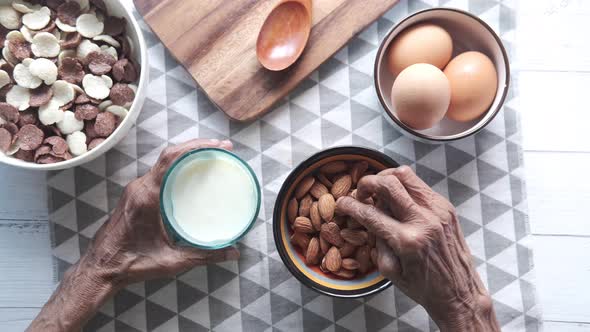 Close Up Senior Women Hand Holding a Bowl on Almond alt