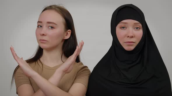 Confident Slim Woman in Hijab Looking at Camera As Twin Sister Crossing Hands Gesturing No alt