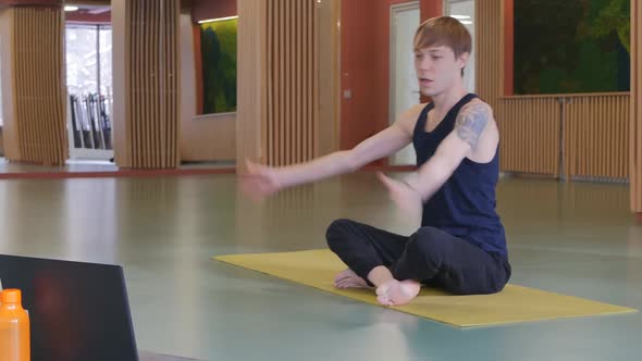 Yoga Coach a Young Attractive Man Completes Online Lessons Doing Namaste