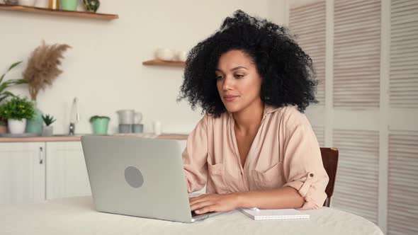 Cute African American Woman Studying Online or Working Remotely Using Laptop Tired and Relaxing alt