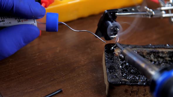 Person in Sterile Gloves Solders Wires on Helping Hand alt