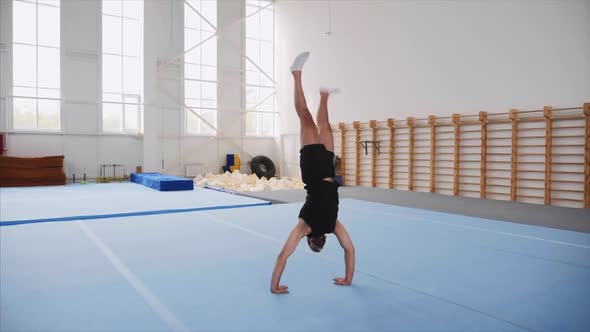 A Sportsman Is Doing a Cartwheel and a Double Back Flip and Lands, Steadicam. alt