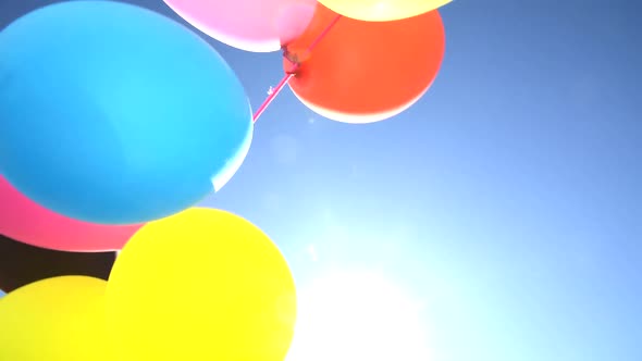 Children Colored Balloons Seen From Below Against The Sun, As A Festive Background.