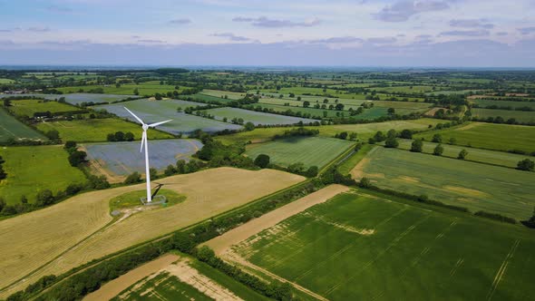 Ariel footage of wind turbine and beautiful English countryside in Northamptonshire with stunning sk alt