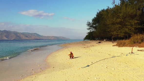 Angler handsome traveller relaxes and enjoying activities at beach on sunny blue and white sand back alt