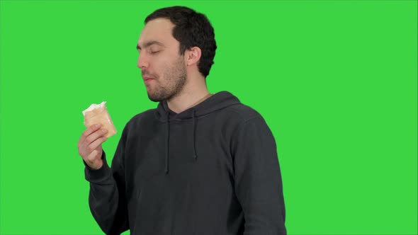 Handsome Young Man Eating Ice-cream on a Green Screen, Chroma Key alt
