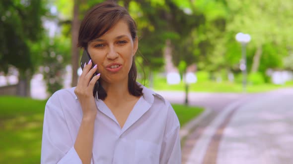 Portrait Millennials Girl Has Negotiations Use Cellphone on the Run in Park alt