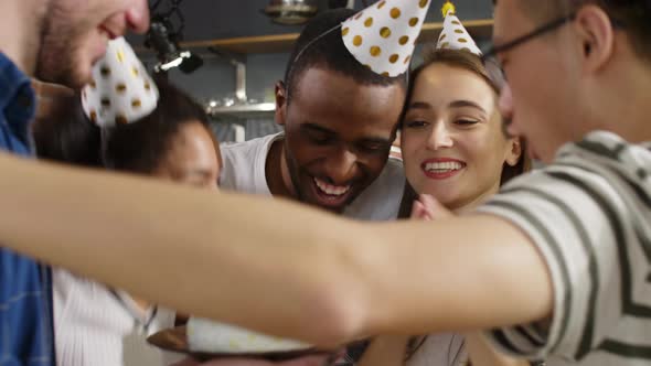 Birthday woman blowing out candles on cake