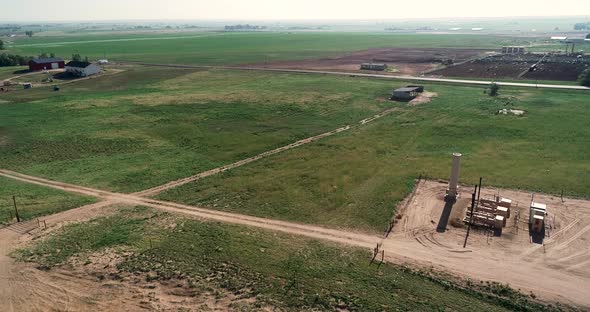 Rising shot of ranches near fracking pad and dairy fields Northern Colorado Weld County June 2022. alt
