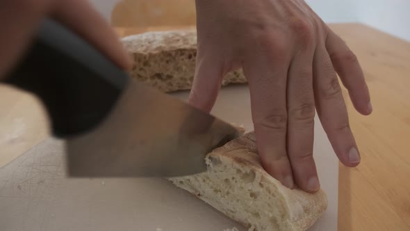 Hands cut typical bread from Madeira called bolo do caco. Handheld shot alt