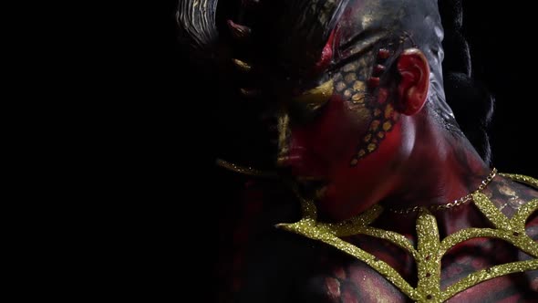 Female demon with red skin and eyes turns quickly to the camera, close up alt