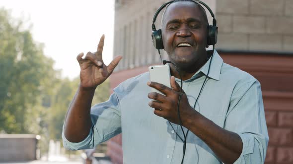 Funny Cheerful Emotional Senior African American Man Wearing Headphones Have Fun Moving Listening alt