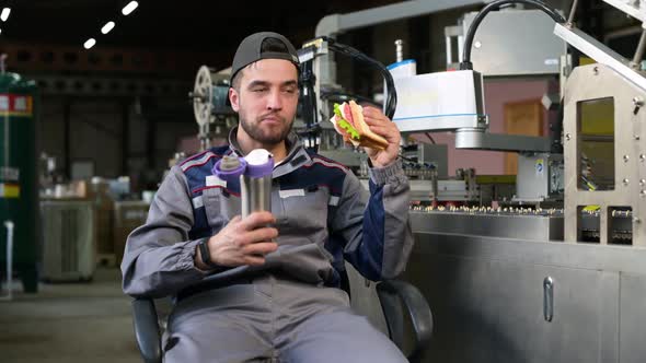 A young man takes food at workplace during work hours or during his lunch break alt
