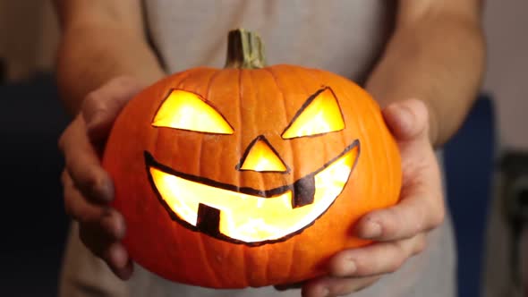 The Young Master Made a Jack-o-lantern for the Halloween party.A Young Man, Holds Out a Halloween alt