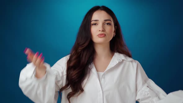 Annoyed Young Brunette Woman Scolding Someone Against Blue Background