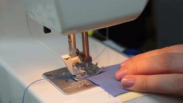 Fashion designer sews on a sewing machine alt