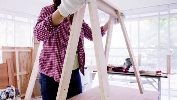 Stylish craftswoman working in carpentry. Woodwork and furniture making concept. alt