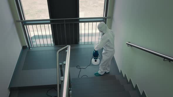Top view of person in protective suit disinfecting the staircase. Shot with RED helium camera in 8K. alt