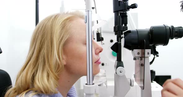 Optometrist examining female patient on slit lamp alt