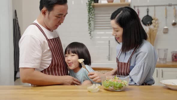 Asian boy who dislikes vegetables, is being asked by his parents to eat vegetables for his health.