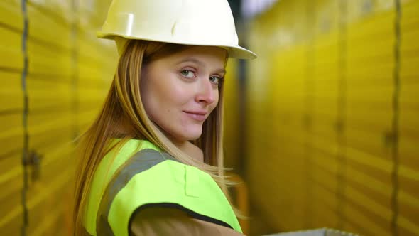 Charming Young Woman Turning to Camera Raising Eyebrows Flirting Standing in Warehouse alt