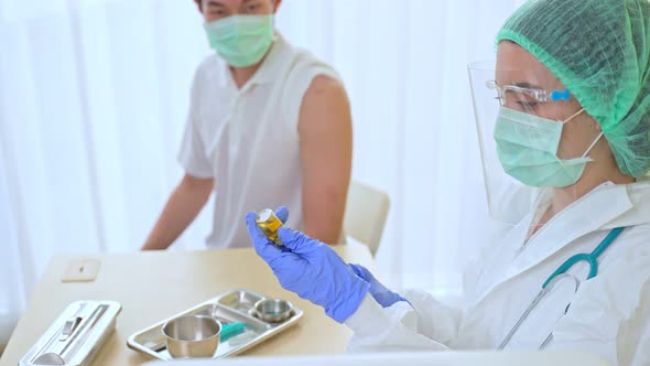 Female doctor take syringe equipment give vaccine treatment care to male patient check up for Covid. alt