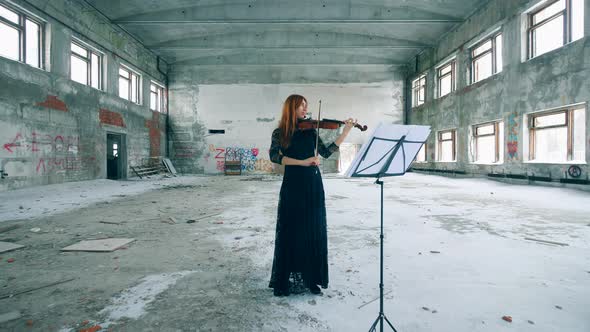 Female Violinist Plays a Violin in an Abandoned Building alt
