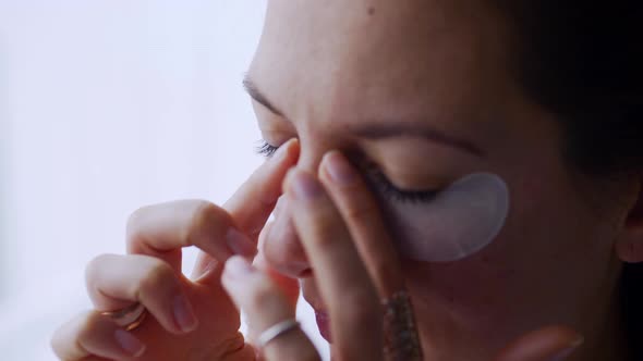 Woman Puts Patch Under Eye Taking Care of Skin