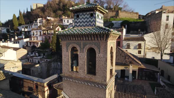 Stunning design of bell tower of Mudejar church, Granada, Spain; aerial orbit