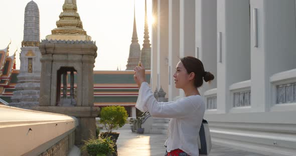 Woman go travel and take photo on cellphone at bangkok
