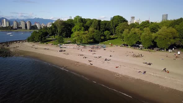 People Enjoying The Reopened Kitsilano Beach During Summer With Downtown Skyline And English Bay Bea alt