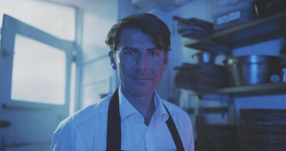 Chef standing in kitchen looking into the camera alt
