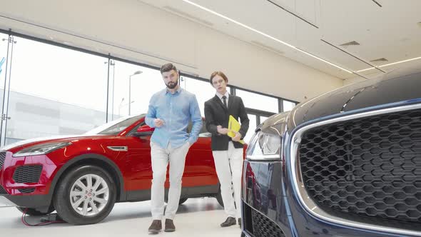 Bearded Man Examining New Car on Sale at the Dealership