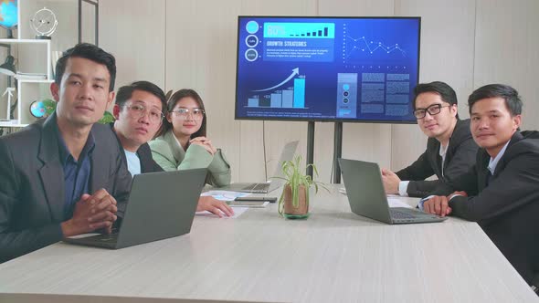 Young Asian Team Have Meeting In A Conference Room, Have Conference Video Call With They're Boss alt