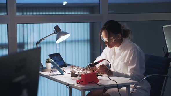 African American Electronics Specialist Making Tests on Electronic Board with Multimeter Tester in alt