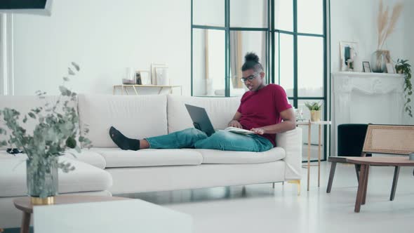 Living Room with an Africanamerican Man Having Online Lesson alt
