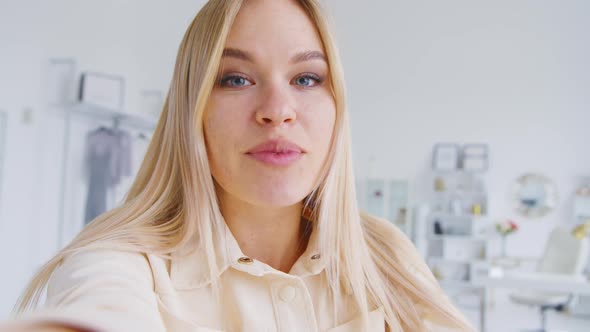 Smiling young girl talking to camera making conference video call alt