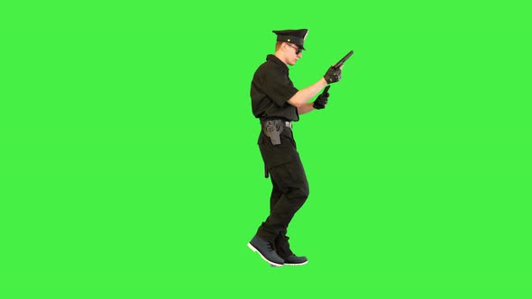 Policeman Walks Doing Some Exercices with His Gun on a Green Screen Chroma Key