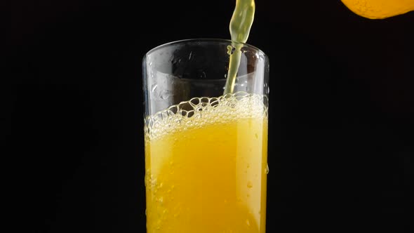 Pouring Orange Drink. Slow Motion. Carbonated orange drink is poured into a glass. Pouring orange ju