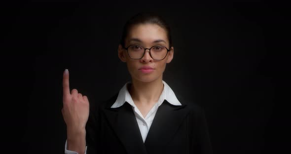 Business Woman with Glasses with a Serious Face Shows One Finger