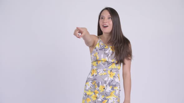 Young Happy Multi-ethnic Tourist Woman Looking Shocked and Pointing Finger alt