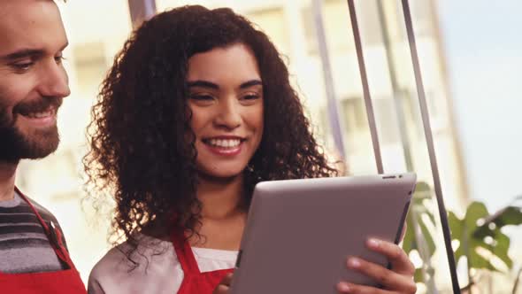 Smiling waiter and waitress using digital tablet alt