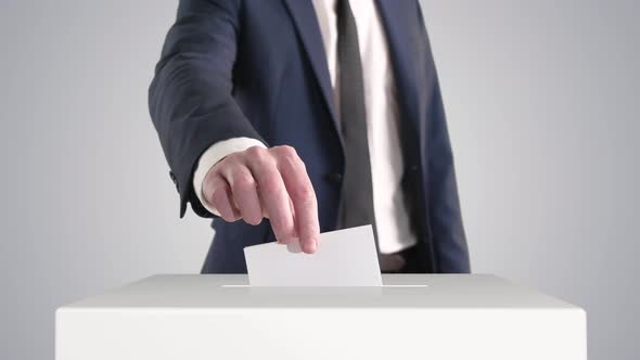 Voting. Man Putting a Ballot into a Voting Box.