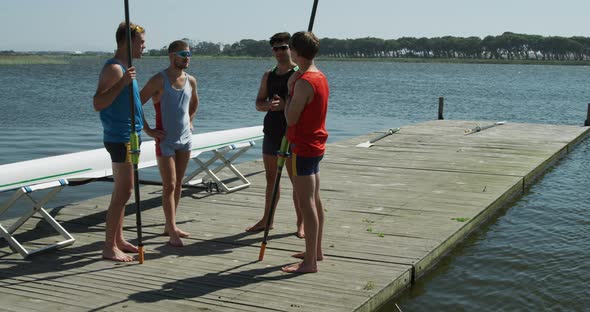 Side view of male rower discussing on the jetty alt