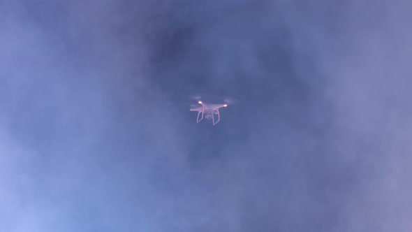 White drone shoots video on the background of the night sky. lots of smoke.
