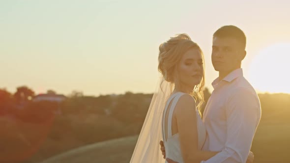 The Wedding Couple is Having Fun at Sunset on the Mountain Hills By the River alt